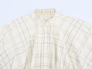 Detail of checkered blouse collar featuring a mandarin stand-up neck and pleat accents