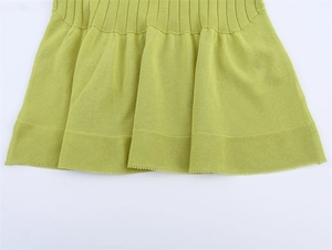 Detail of lime green knit hem with ruffled pleats and fine ribbing texture on short sleeve top