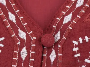 Broderie détaillée et bouton rond sur un haut en lin rouge foncé à col en V