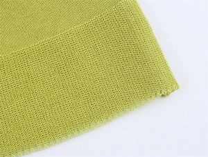 Close-up of lime green knitted mesh fabric with intricate woven edge and breathable texture