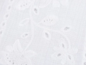 Vista dettagliata del ricamo floreale bianco e del design a intaglio sul tessuto