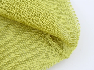 Close-up of lime green knitted mesh fabric with detailed openwork texture and stitching