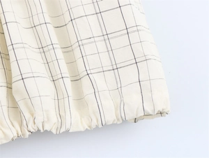 Macro detail of elastic cuffs on a plaid bomber jacket with cream windowpane check fabric