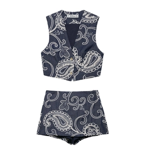 Detailed view of paisley embroidery and golden buttons on navy blue vest and shorts set