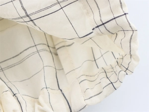 Detailed macro shot of the plaid jacket featuring elastic cuffs and cotton texture