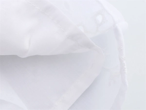 Gros plan sur le tissu brodé blanc avec doublure lisse et finitions de couture précises