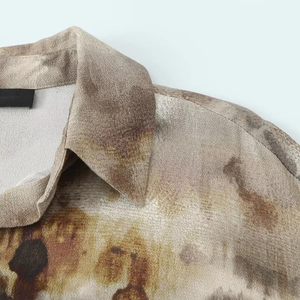 Detail of lapel collar on tie-dye shirt with abstract earth-tone ink pattern and texture