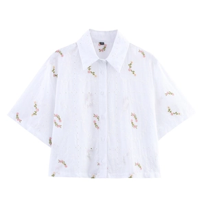 Chemisier blanc à manches courtes avec broderie florale et détails ajourés fins