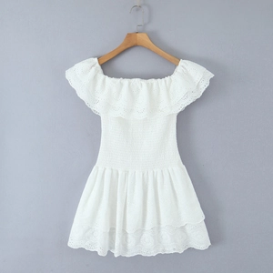 Dettaglio ricamo inglese su vestito estivo bianco con spalle scoperte e vita a nido d'ape