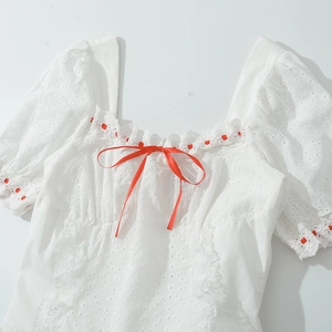 Top blanc en dentelle à manches bouffantes avec rubans et nœuds en satin rouge