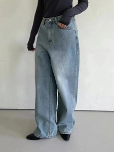 Detail shot of light blue high-waisted wide-leg denim jeans with metal button closure