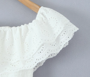 Dettaglio ricamo inglese bianco in cotone con eleganti balze a strati e volant