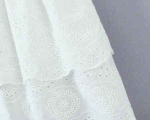 Dettaglio ravvicinato del pizzo bianco Broderie Anglaise con bordi ricamati a smerlo