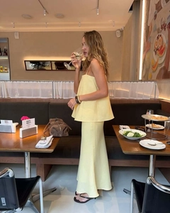 Detail of light yellow two-piece summer set with tiered camisole and flowing maxi skirt