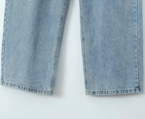 Detail view of double-stitched hem on light blue washed straight leg denim jeans