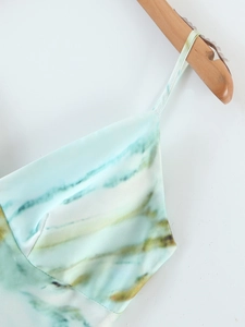 Détail de robe nuisette en satin avec imprimé tie-dye bleu et vert et fines bretelles