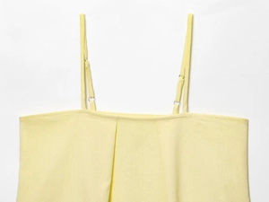 Detail of light yellow camisole with adjustable straps and pleated neckline texture