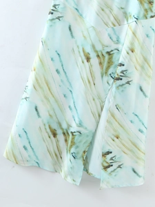 Dettaglio del tessuto in raso blu menta con stampa marmorizzata tie-dye e spacco alto