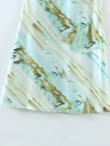 Détail du tissu de robe à imprimé marbre avec texture soyeuse et couture de l'ourlet