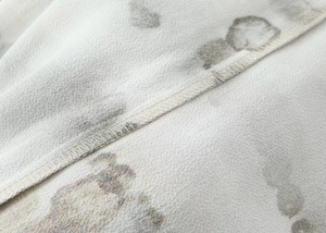 Macro shot of abstract tie-dye fabric showing delicate stitching and matte texture