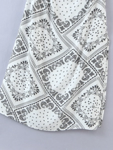 Detail view of the side slit and paisley patchwork print on this white summer dress