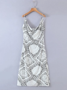 Detail of white paisley print dress featuring thin straps and elegant cowl neckline design