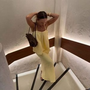 Women's two-piece yellow summer set with minimalist camisole top and long flowy skirt