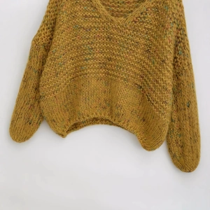Women's mustard yellow V-neck chunky knit sweater with colorful flecks in a loose fit