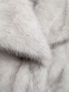 Detailed macro view showing the soft texture of grey and white faux fox fur coat fabric