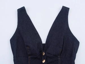 Close-up of deep V-neck dark denim top with metallic buttons and contrast stitching details