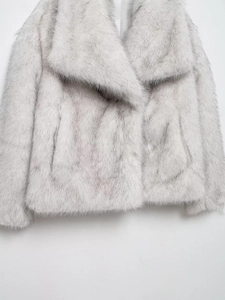 Close-up of fluffy faux fur texture and lapel collar on a luxury silver grey coat