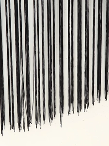Détail des franges noires sur la robe d'été asymétrique avec une texture fine
