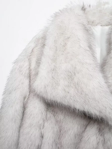 Close-up of the fluffy faux fur texture and collar detail on a gradient winter coat