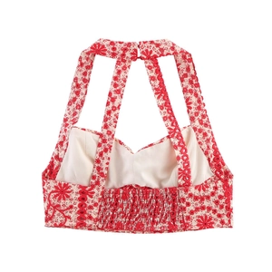 Detail of red floral embroidered crop top featuring smocked back and halter button closure