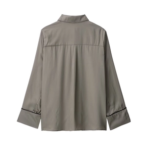 Rear view of sleek taupe satin long-sleeve shirt with contrasting black cuff trim details