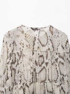 Detail of snake print pattern and back pleats on long-sleeve chiffon top for women