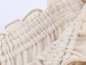 Detailed macro view of the elastic smocked waist with ruffle edge on a floral skirt
