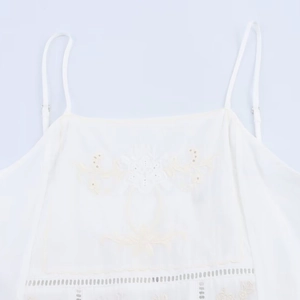 White camisole top with floral embroidery and thin straps for a minimalist summer style
