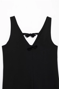 Detailed view of the elegant V-neckline with decorative black velvet bows on the dress