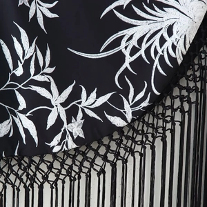 Robe d'été pour femmes en tissu noir avec broderie de feuilles blanches et franges
