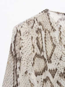 Detailed view of the shoulder pleats and snake skin print on this elegant blouse
