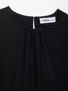 Detail of round neckline with delicate pleats and button closure on black linen top