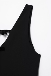 Detailed view of black spring dress featuring elegant velvet bow and fine tailoring