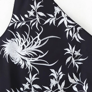 Robe asymétrique noire d'été avec motifs floraux blancs et détails de glands élégants