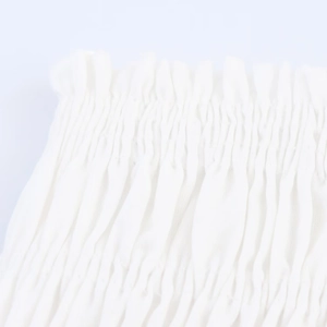 Close-up of the smocked elastic waist detail on a white spring midi dress