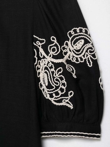 Close-up of black cotton-linen sleeve with white paisley embroidery and elastic cuff detail