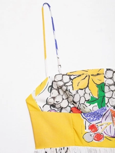 Detail of vibrant fruit print dress with thin straps and bright yellow color block