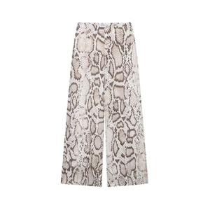 Detailed view of the snakeskin print fabric on wide-leg trousers for a stylish look