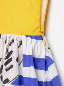 Close-up of yellow fabric with blue stripes and leaf print featuring hidden zipper detail