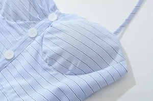 Close-up of light blue striped halter dress featuring white buttons and fine texture